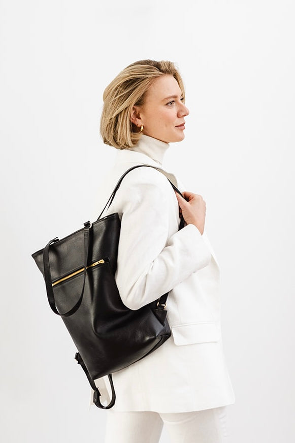 Woman carrying The Backpack by Ella Jackson Australia – side profile view, minimalist styling with white blazer and trousers.