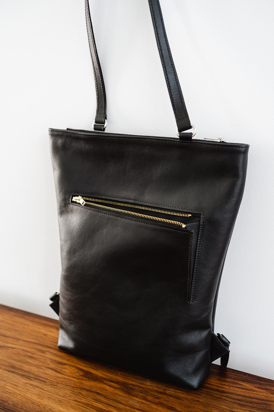 Angled close-up of The Backpack by Ella Jackson Australia – showcasing full grain leather texture and front zipped pocket detail.
