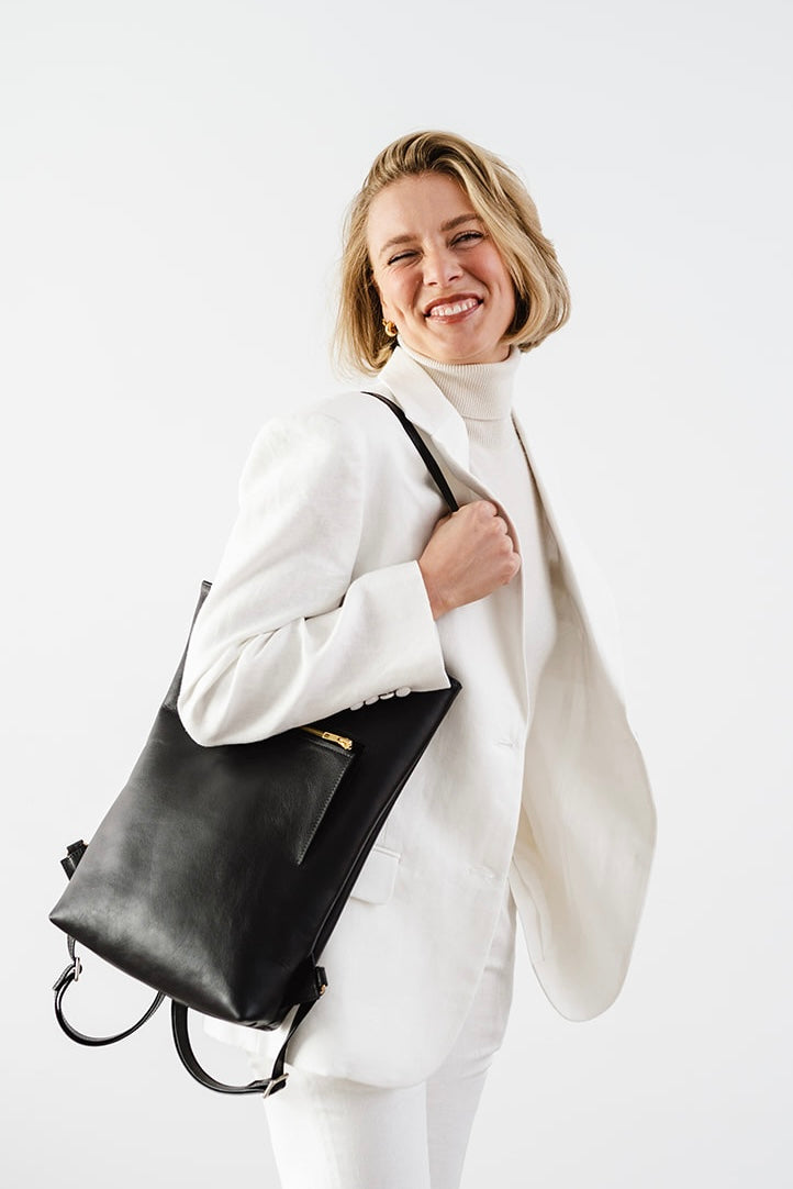 Woman smiling while carrying The Backpack by Ella Jackson Australia – relaxed and minimalist portrait in white tailoring.