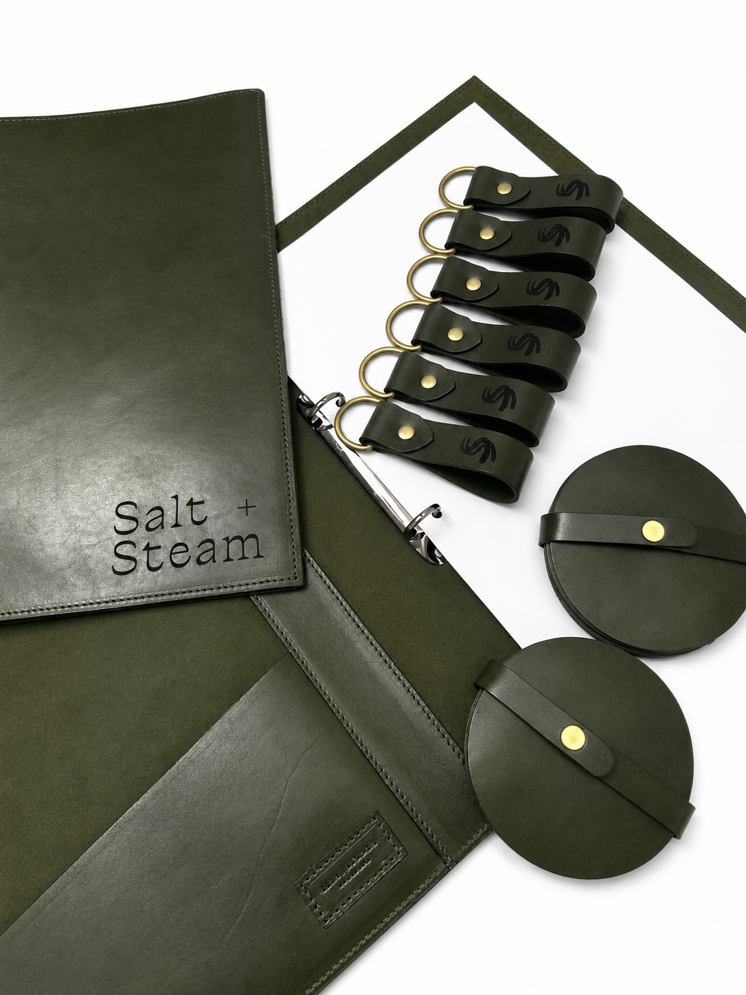 Custom green leather Airbnb compendiums, lasered keyrings and matching coasters by Ella Jackson Australia, handcrafted for Salt + Steam and displayed in STUDIO Ella Jackson, Hobart.
