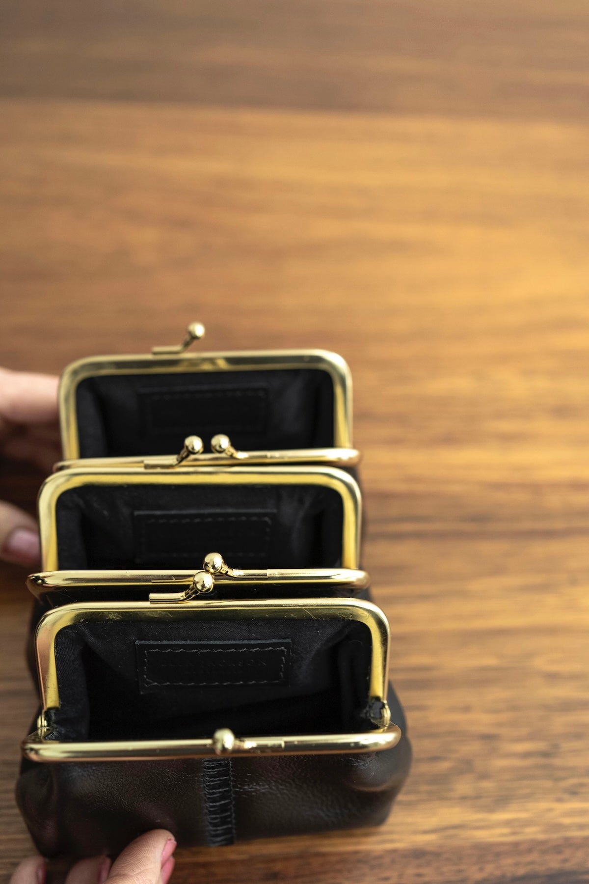 The Frame Purse by Ella Jackson Australia — interior view of three black leather purses with gold clasp, fully lined