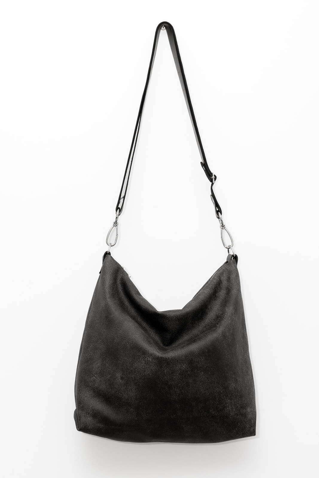 Grey carryall bag with black strap and silver hardware hanging on white background
