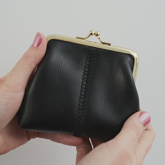 The Frame Purse by Ella Jackson Australia — video demonstration showing the black leather purse from all angles, with hands opening and closing the gold clasp against a white background