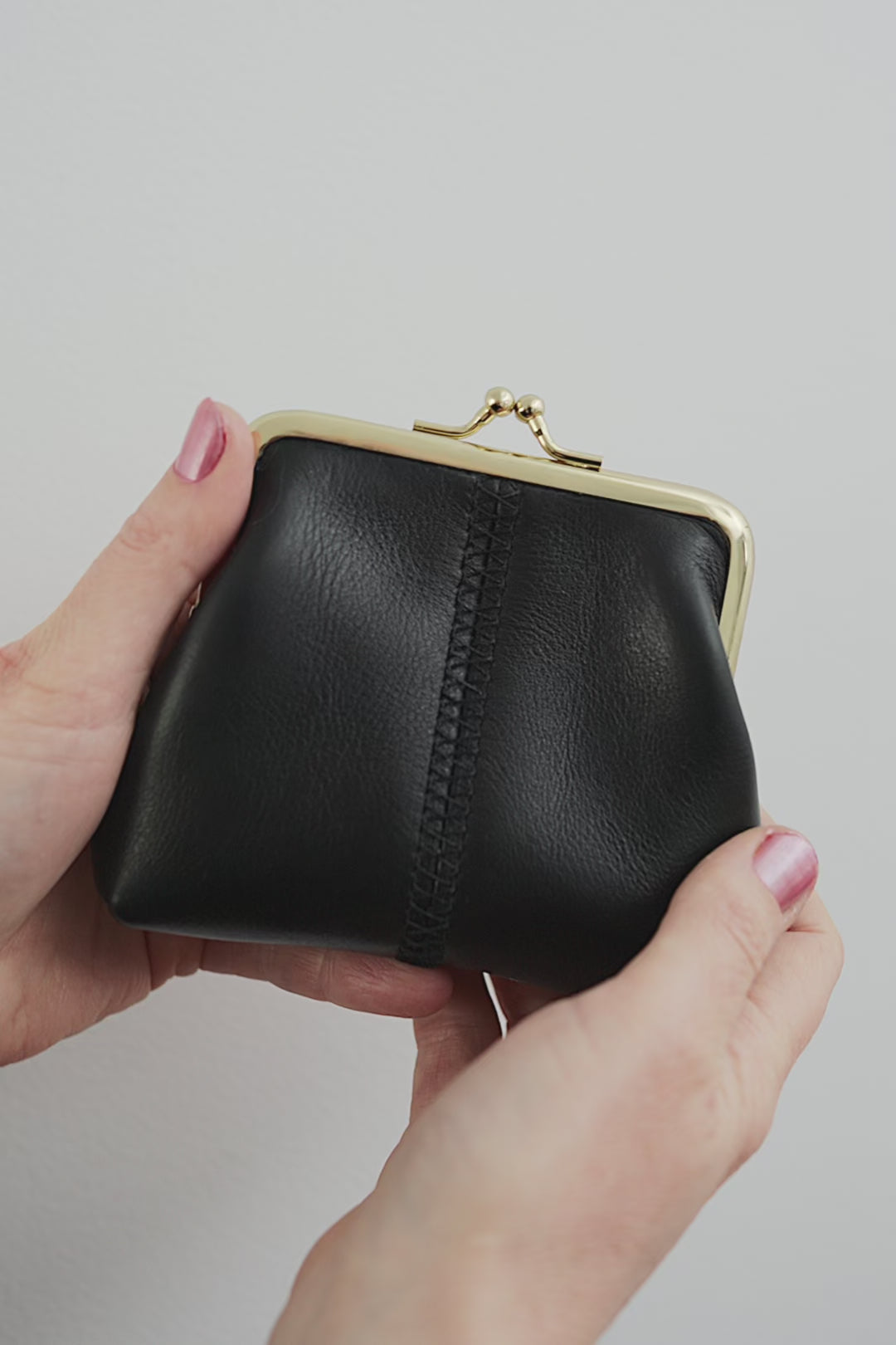The Frame Purse by Ella Jackson Australia — video demonstration showing the black leather purse from all angles, with hands opening and closing the gold clasp against a white background