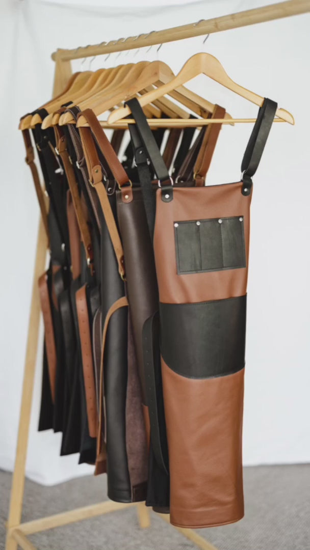 Video showing the features of the Ella Jackson Jeweller Leather Apron. This variant has a tan leather body, black straps and pockets, black lining and silver hardware. The apron has been put on a mannequin to show the front and back